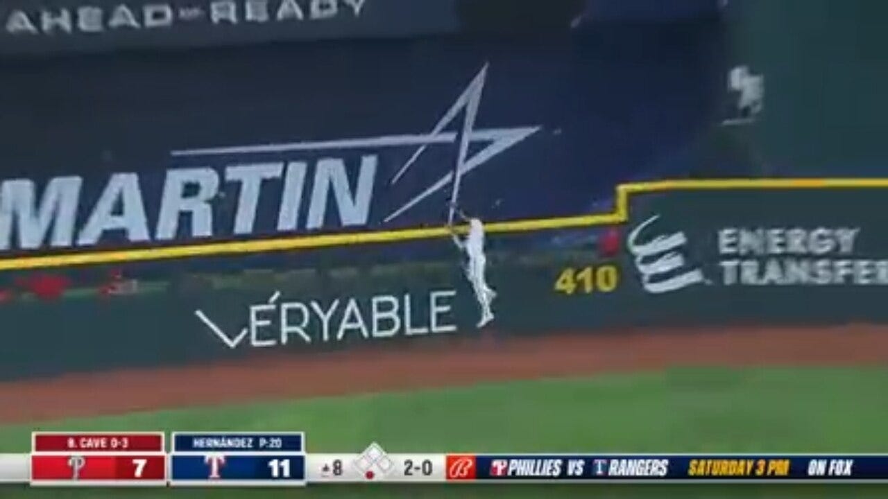 Rangers' Bubba Thompson makes a leaping catch at the wall to rob a home run