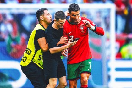 Two fans enter field for selfies with Cristiano Ronaldo during match at Euro 2024